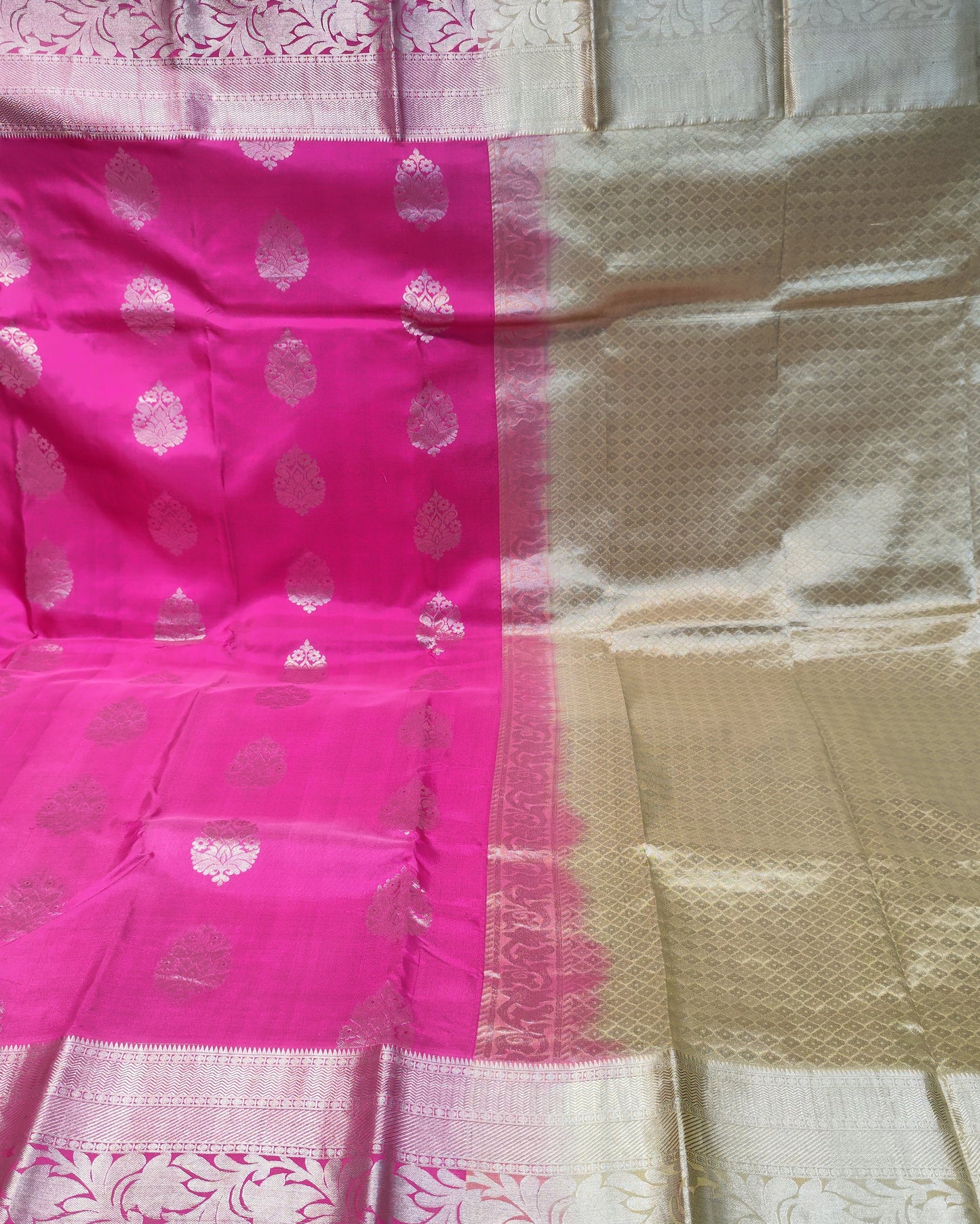 Pink & Cream Kanjeevaram silk saree with metallic zari brocade patterns, held up to display its drape and design.