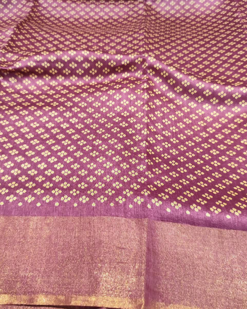 A close-up of a Tussar Silk & Digital Printing Pink Saree showing a repeating ikat-style motif and a wide gold-trimmed border.