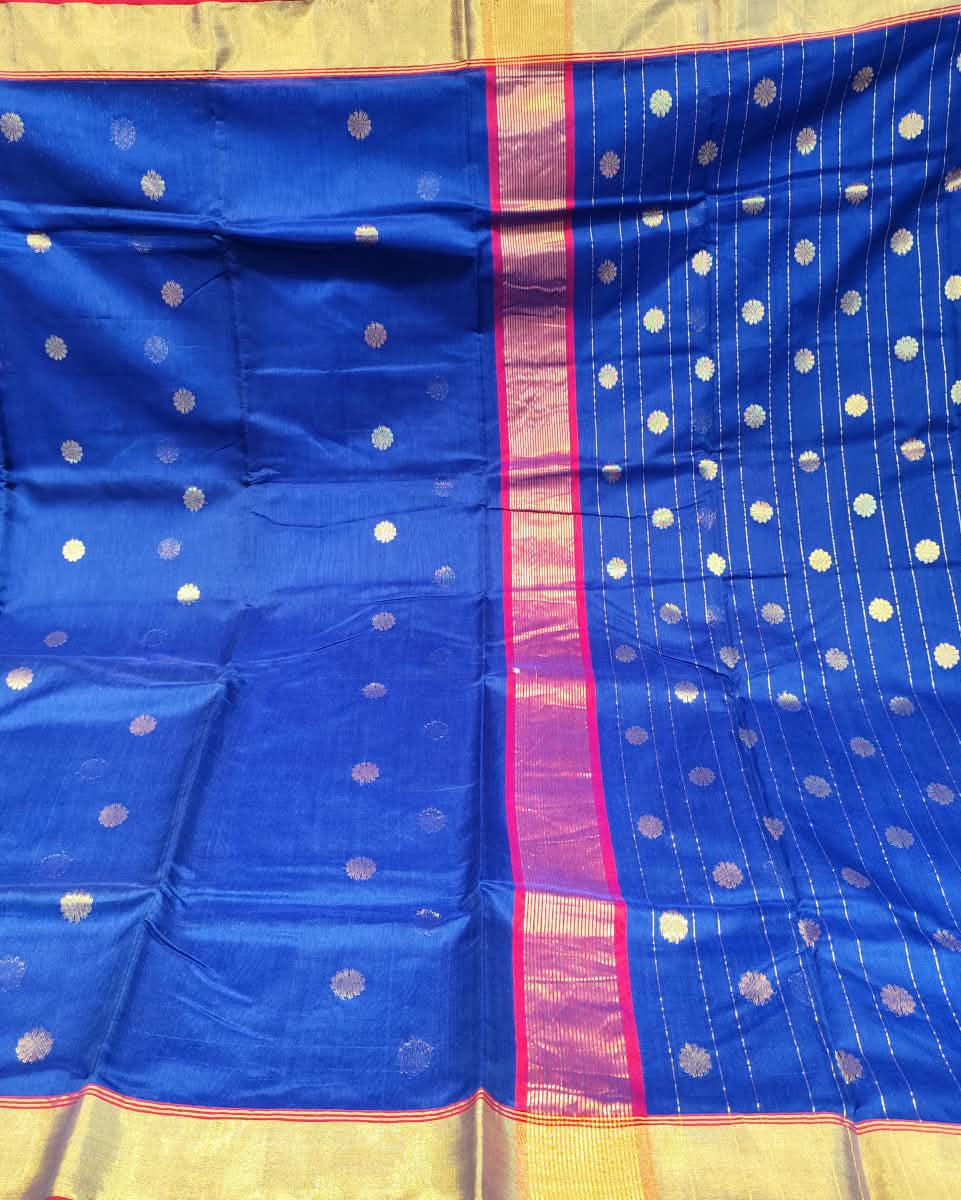A royal blue silk saree with gold zari motifs and a pink and gold border, displayed flat.