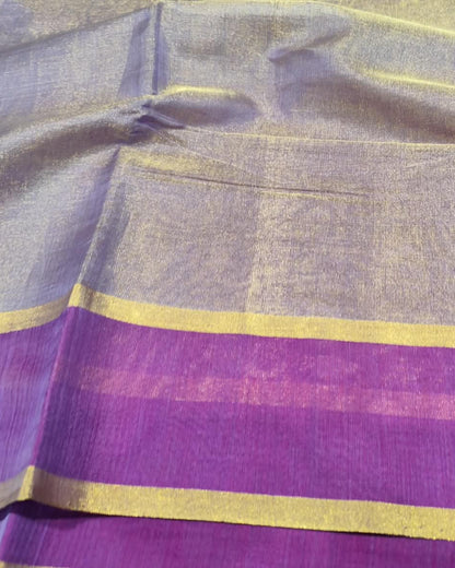 A close-up of a purple and lavender fabric with metallic gold zari stripes and borders.