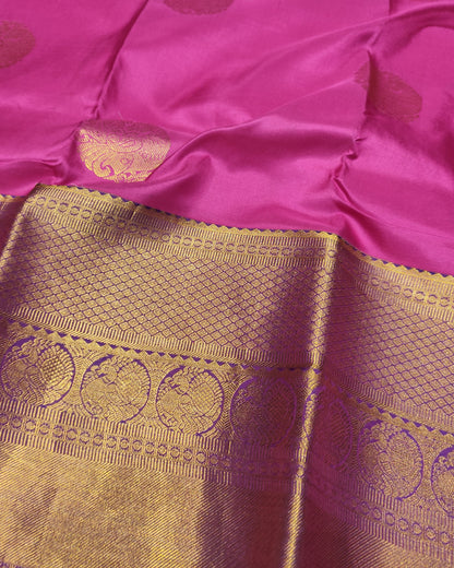 A close-up of a Kanjeevaram Silk Orange & pink silk saree with a wide gold zari border featuring intricate woven motifs.