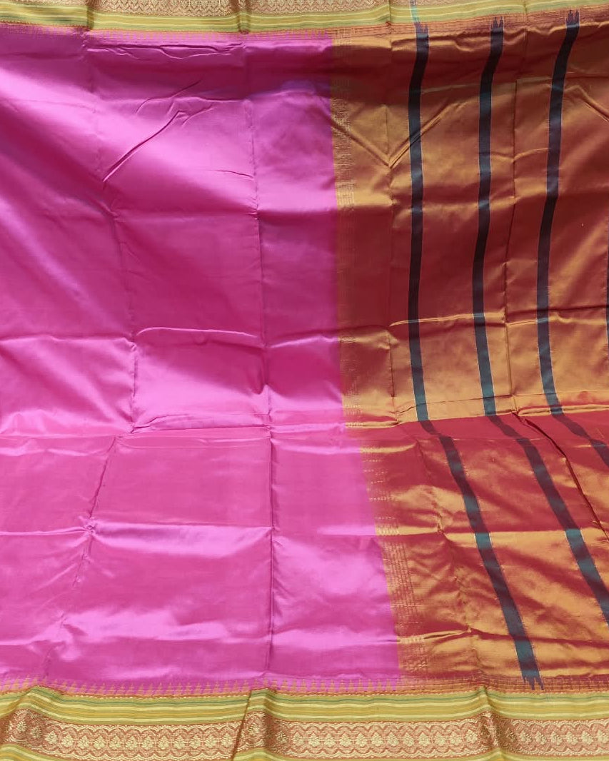 A pink and orange silk saree with black stripes and gold borders, held up to display its full pattern and drape.