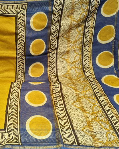 A close-up of a patterned Maheshwari Silk Cotton Saree | Yellow & Blue  featuring a dominant golden-yellow body, a royal blue border with yellow circular motifs, and a beige and gold floral patterned section.