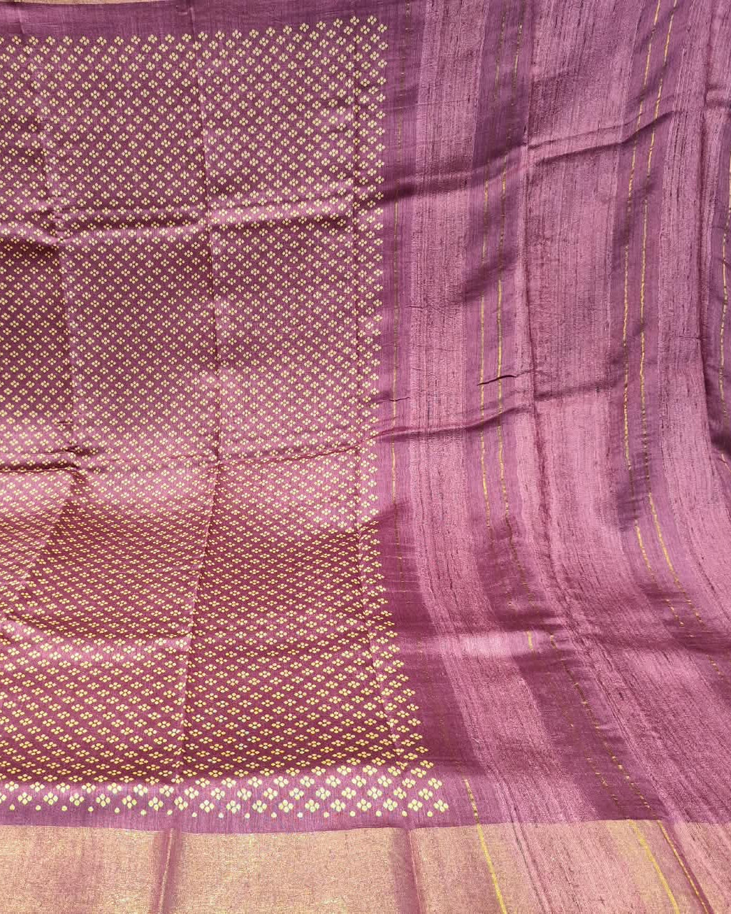 A close-up of a pink and gol Tussar Silk & Digital Printing Pink Saree showing its woven texture, geometric motifs, and striped border.