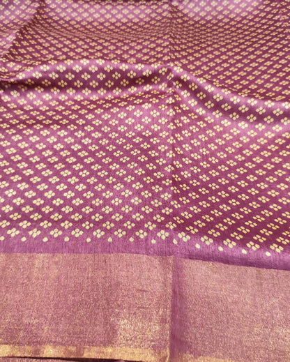 A close-up of a Tussar Silk & Digital Printing Pink Saree showing a repeating ikat-style motif and a wide gold-trimmed border.