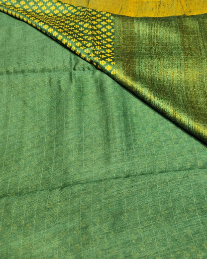 A close-up of a Tussar Silk Saree | Green | Digital Print showing its fine texture, subtle vertical stripes, and a contrasting yellow and green patterned border.