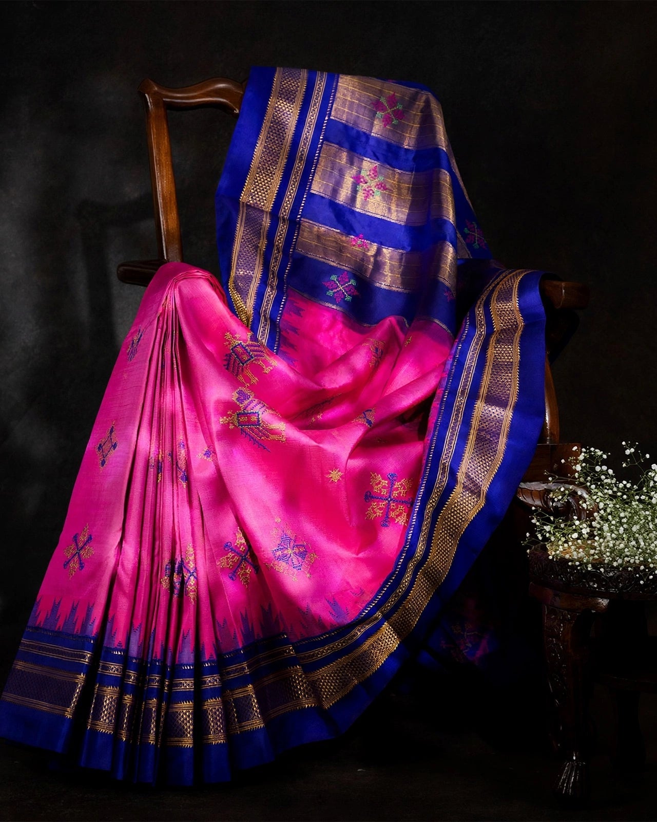 A draped view of Hot Pink Ilkal saree with Blue accents and traditional Indian Kasuti embroidery